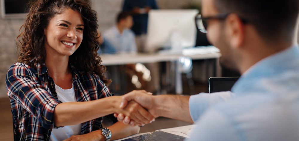 Young woman signing contracts and handshake with a manager