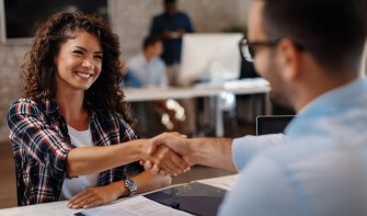 Young woman signing contracts and handshake with a manager